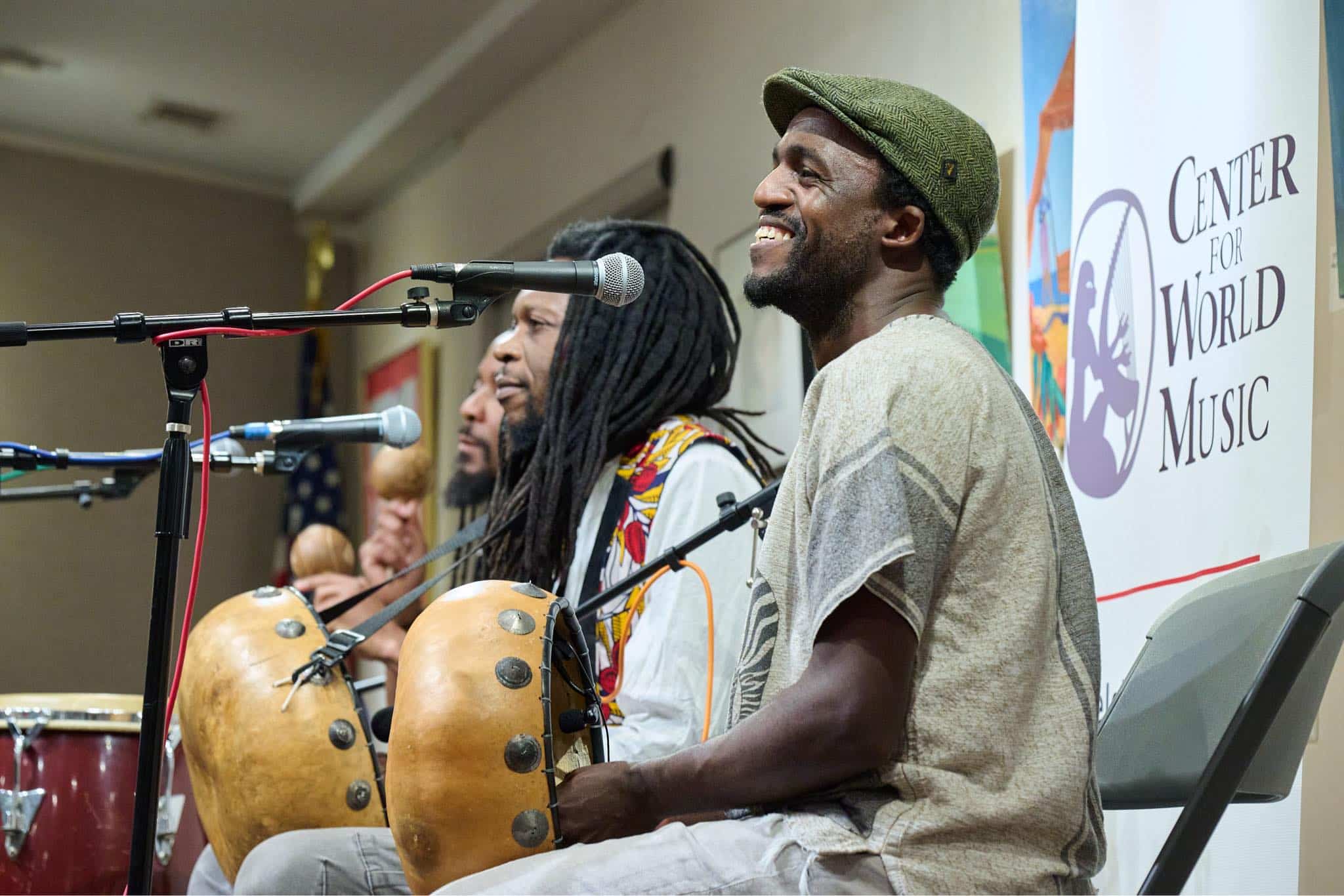 Three men play instruments on a stage.