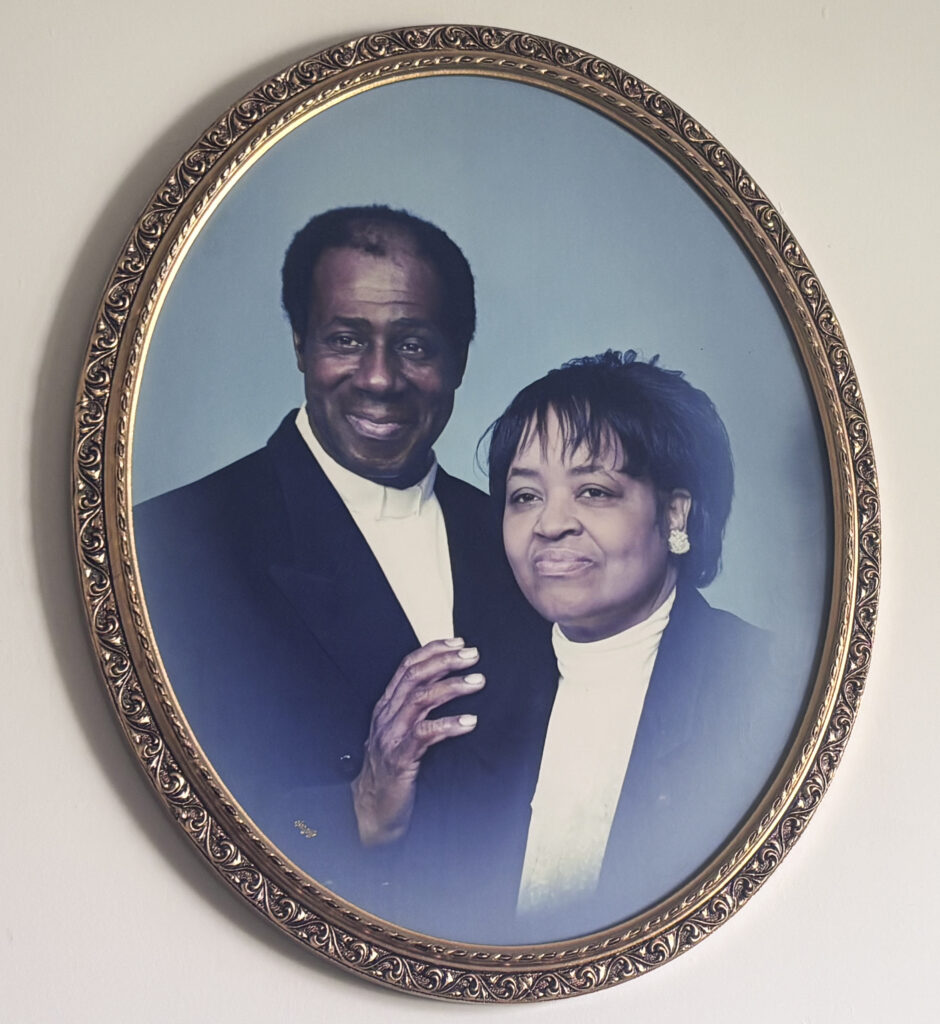 A framed photo of a couple hangs on a white wall.