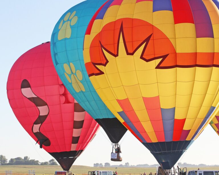 Three hot air balloons float in the air.