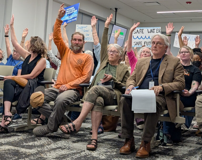 People are sitting and raising their hands.