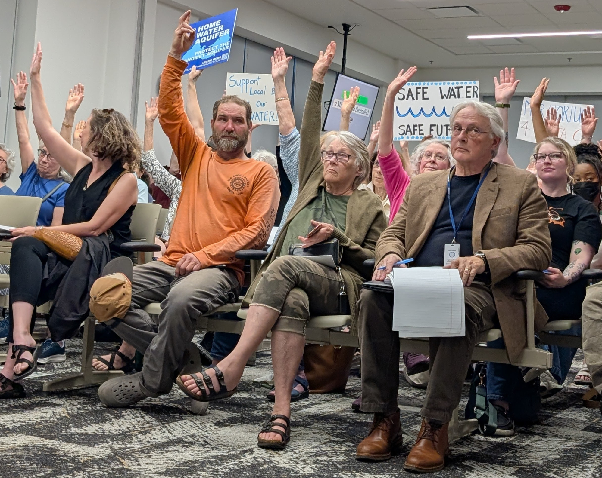 People are sitting and raising their hands.