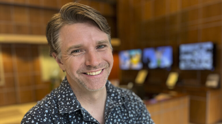 A white man with short, light brown hair smiles at the camera.
