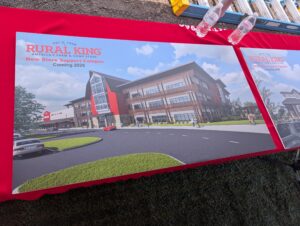 A rendering of the new Rural King headquarters. The building is three stories with a red barn in the center.