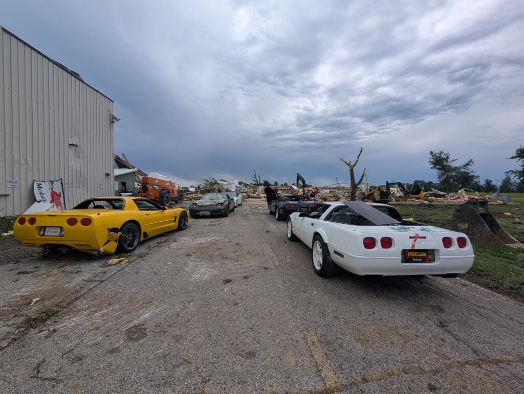 Smashed Corvettes line both sides of a road.