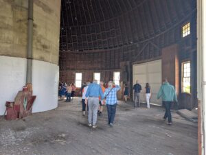 People walk through a round barn.