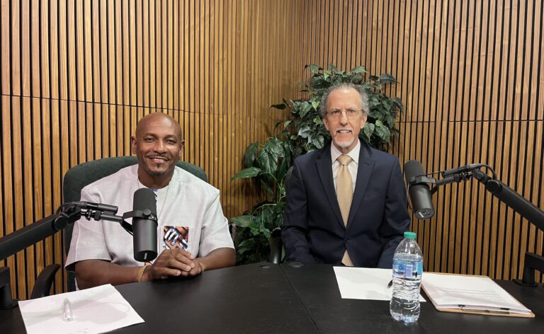 two men sitting in podcast studio at IPM.