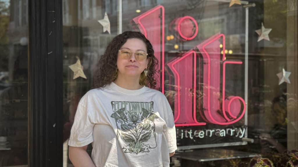a person stands in front of a sign that says "lit"