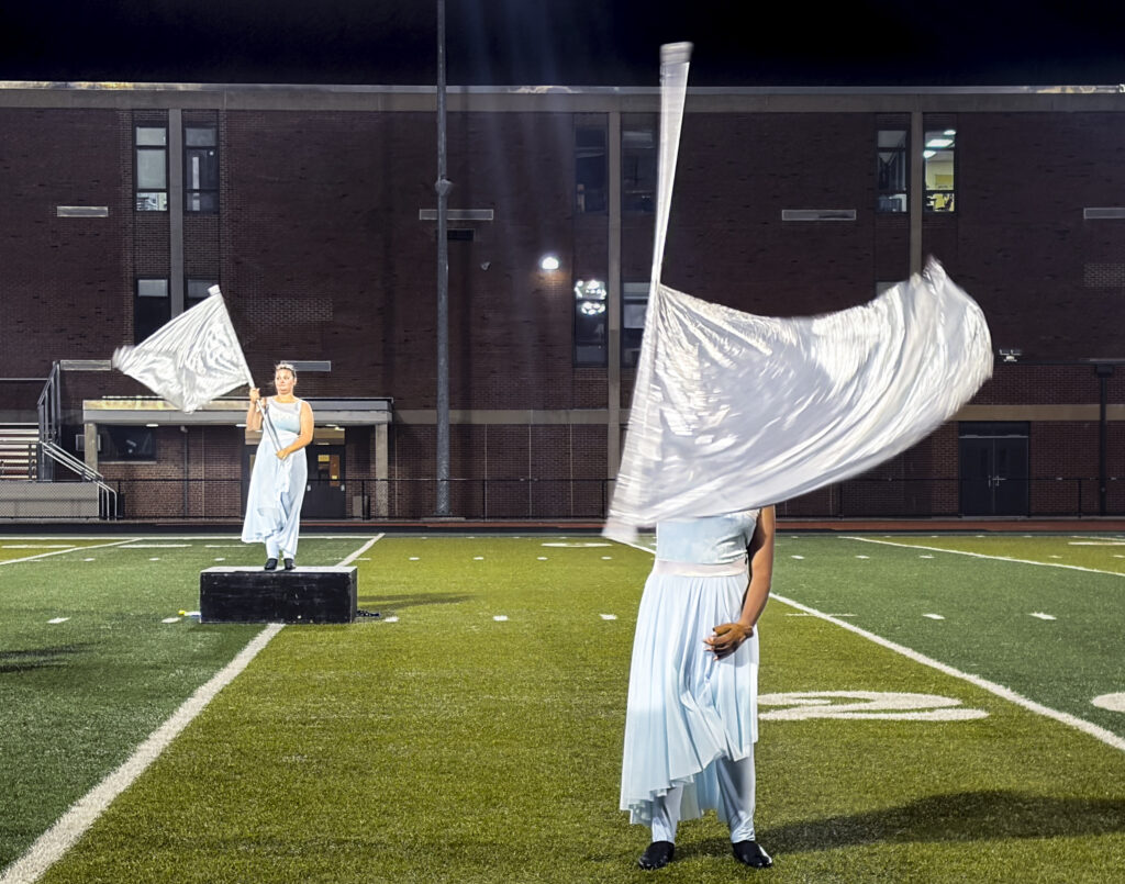 two colorguard members on a football field