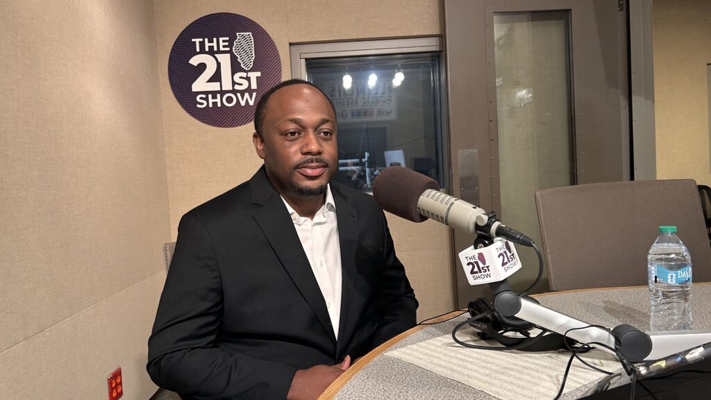 Whitfield Harrington Jr. sits in front of a microphone.
