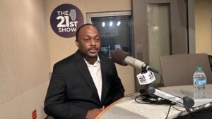 Whitfield Harrington Jr. sits in front of a microphone.