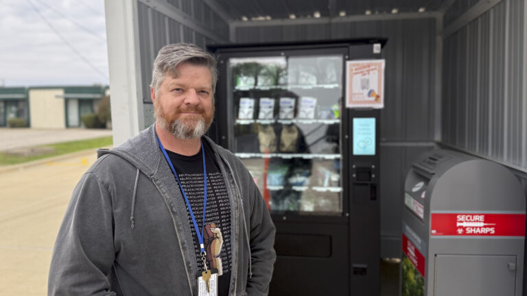 A man stands in front of a harm reduction vending machine