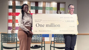 two people hold a check for $1 million from an anonymous donor