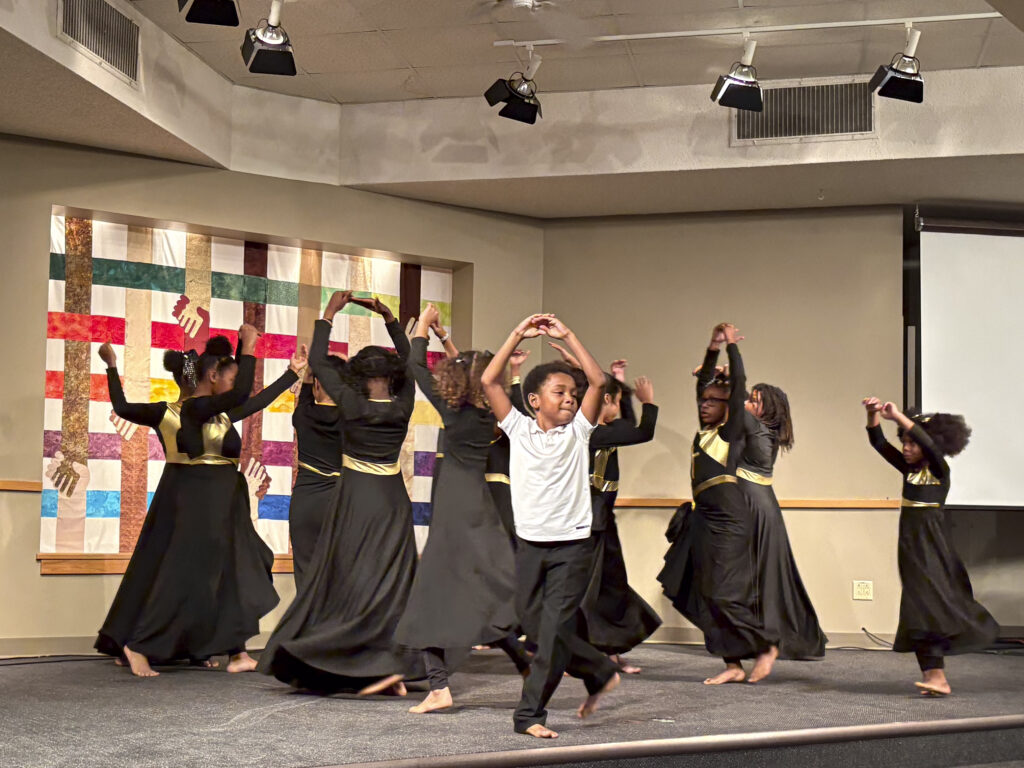 a group of children dance on stage