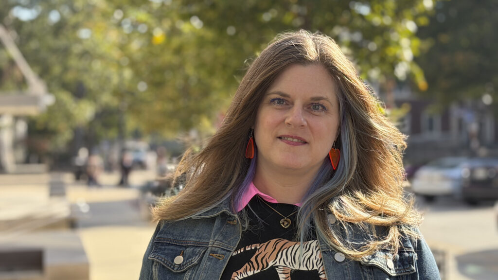 a woman poses for a photo outside